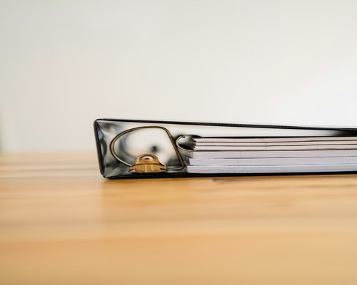 A detailed paper binder containing organized household planning checklists and seasonal billing trackers