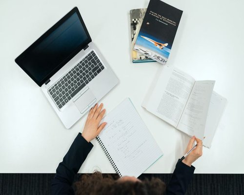 An open workspace containing clear academic texts, notebooks, and reference guides detailing consumer metrics in Canada